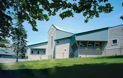 A large stone and green metal-roofed institutional building